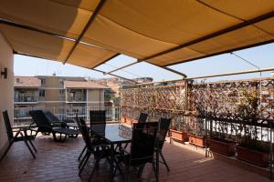 a patio with tables and chairs on a balcony at Terrazza sul Parco in Rome