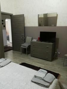 ein Schlafzimmer mit einem Bett und eine Kommode mit einem Spiegel in der Unterkunft Casa Archimede in Syrakus