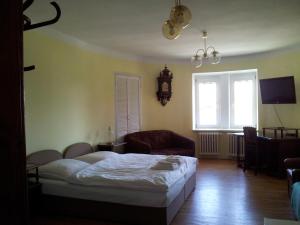 a bedroom with a bed and a chair and a window at Pension Siesta in Třeboň