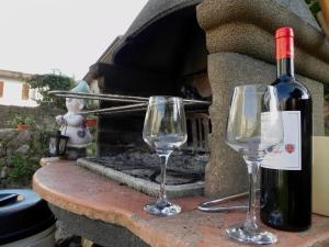 uma garrafa de vinho e dois copos de vinho numa mesa de pedra em Villa Carlotta em Moniga
