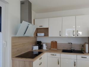 a kitchen with white cabinets and a sink at Hafenzauber in Ueckeritz