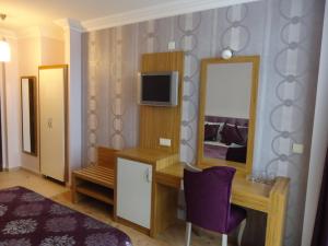 a hotel room with a vanity and a mirror at Bilkay Hotel in Alanya