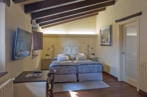 a bedroom with a bed and a table in a room at Hotel Cal Sastre in Santa Pau