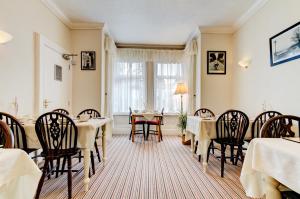 a dining room with tables and chairs and a window at Dolphin Guesthouse in Scarborough