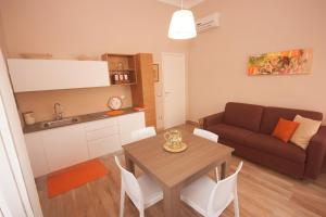 eine Küche und ein Wohnzimmer mit einem Tisch und einem Sofa in der Unterkunft Il Punto a Maglie in Maglie