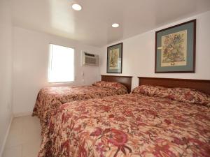 Habitación de hotel con 2 camas y ventana en Shore Beach Houses - 111 Lincoln Ave, en Seaside Heights