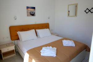 a bedroom with a bed with white towels on it at Kappatos Studios & Apartments in Lassi