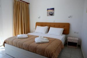 a bedroom with a large bed with towels on it at Kappatos Studios & Apartments in Lassi