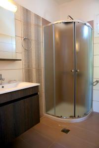 a shower with a glass door in a bathroom at Kappatos Studios & Apartments in Lassi