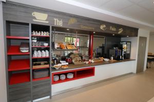 a bakery with a counter with food on display at Hotel Arena Toulouse in Toulouse