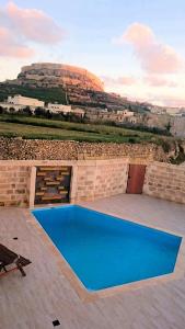 una piscina en un patio con una montaña en el fondo en Citadel View Farmhouse en Victoria