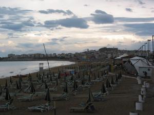 a beach with chairs and umbrellas on the sand at Hotel Vela Velo Club Vieste in Vieste