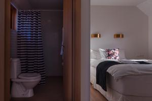 a bedroom with a bed and a bathroom with a toilet at Guesthouse Brekka in Brekka +136 photos