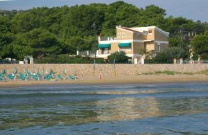una spiaggia con sedie e un edificio sullo sfondo di Hotel Vela Velo Club Vieste a Vieste