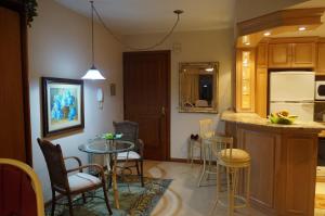 eine Küche mit einem Tisch und Stühlen in einer Küche in der Unterkunft Apartamento Monte Bianco in Gramado