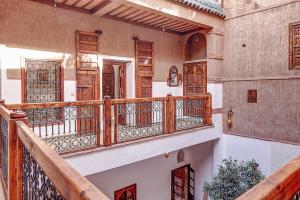 Un balcón de una casa con barandillas de madera en Riad Carina, en Marrakech