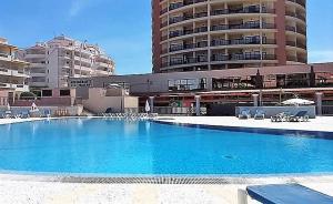 ein großer Pool vor einem großen Gebäude in der Unterkunft Club Praia Mar in Portimão