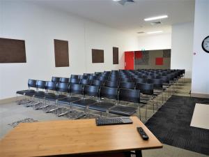 an empty auditorium with chairs and a table with a remote control at Laguna Serviced Apartments in Toowoomba