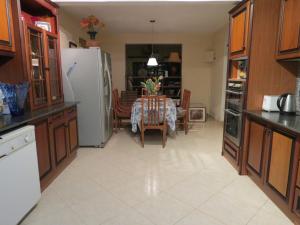 a kitchen with a table and a white refrigerator at Hantana Forest Reserve Inn in Kandy