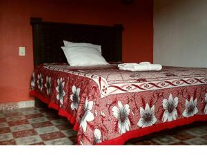 een slaapkamer met een bed met een rode en witte deken bij Hotel Clasico Colonial in Comitán de Domínguez
