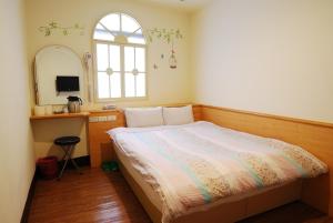 ein kleines Schlafzimmer mit einem Bett und einem Spiegel in der Unterkunft Sun Ho Inn in Taipeh