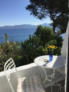 a table and chairs on a balcony with a view of the ocean at Rosys Little Village in Skala