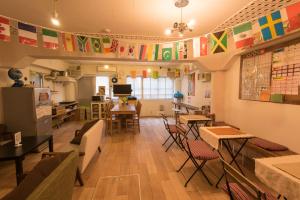 a living room filled with furniture and a kitchen at Hostel Q in Osaka