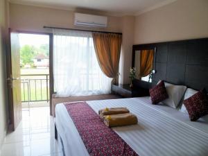 Un dormitorio con una cama grande con una ventana grande. en Nuriani Rooms, en Ubud