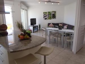Il comprend une cuisine et un salon avec une table et des chaises. dans l'établissement Appartement Les Alizés, à Juan-les-Pins