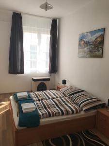 a bed in a bedroom with a window at Éva Apartman in Miskolc