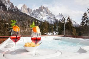 bañera de hidromasaje con 2 copas de vino y un plato de comida en Hotel Europa, en San Martino di Castrozza