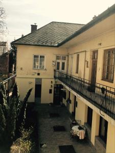 a white house with a balcony and a patio at Éva Apartman in Miskolc