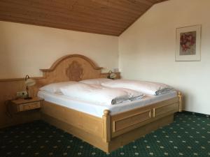 a bedroom with two beds and a wooden headboard at Appartementhaus Seehof in Kirchberg in Tirol