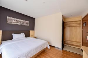 a bedroom with a white bed and a black wall at 7Days Premium Shanghai Wild Animal Park in Nanhui