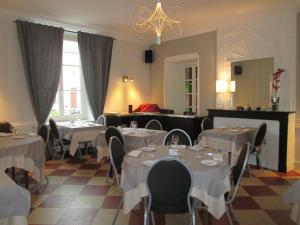 a restaurant with white tables and chairs and a chandelier at Logis Hostellerie Du Cheval Blanc in Sainte-Maure-de-Touraine