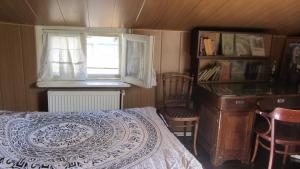 1 dormitorio con cama, ventana y escritorio en Tina's Homestay, en Tiflis