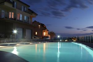 a swimming pool in front of a building at night at Zubci mountain apartment in Bar