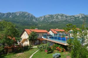 a house with a balcony with mountains in the background at Zubci mountain apartment in Bar