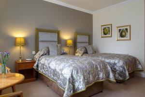 A bed or beds in a room at Garvock House Hotel