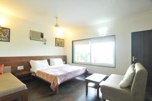 een hotelkamer met een bed en een bank bij Lago villa in Bhopal