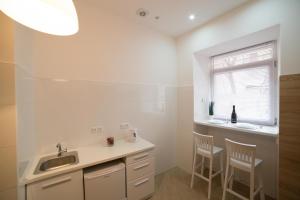 une cuisine avec deux chaises, un évier et une fenêtre dans l'établissement Apartment on SVYATOHO TEODORA SQUARE 5, à Lviv