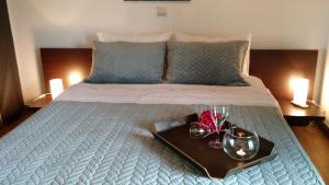 a bed with a tray with two glasses on it at Villa Dimitra in Erateini