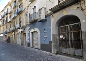 una strada vuota con un edificio blu con una porta di A Due Passi B&B a Castellammare di Stabia