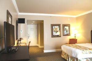 a hotel room with a bed and a flat screen tv at Menger Hotel in San Antonio