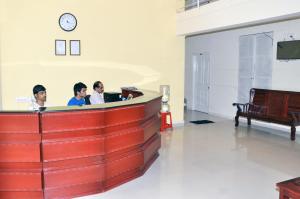 three people sitting at a desk in a waiting room at Vega Residency in Bangalore