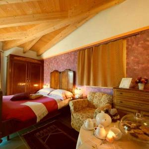 Habitación de hotel con cama y sofá en Villa Amaranta Room and Breakfast, en Edolo