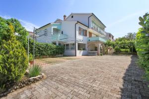 a house with a brick driveway in front of it at Apartments Silvia in Poreč