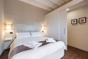 a bedroom with a large white bed with towels on it at Charming Attic Niche in Florence