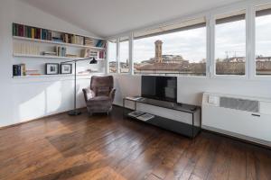 a living room with a television and a chair at Charming Attic Niche in Florence