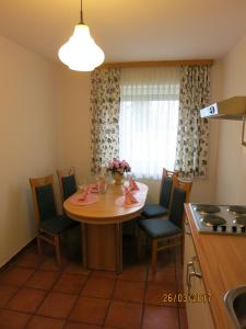 a kitchen with a table and chairs in a kitchen at Ferienwohnungen Kremsbrucker in Klagenfurt